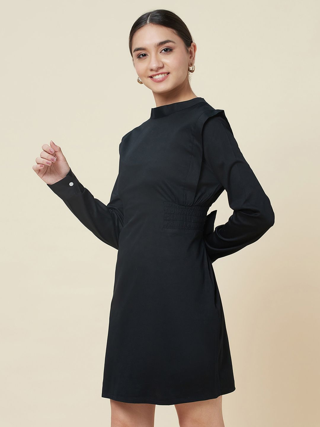 Black high neck dress with side smocking and a belt to cinch the waist