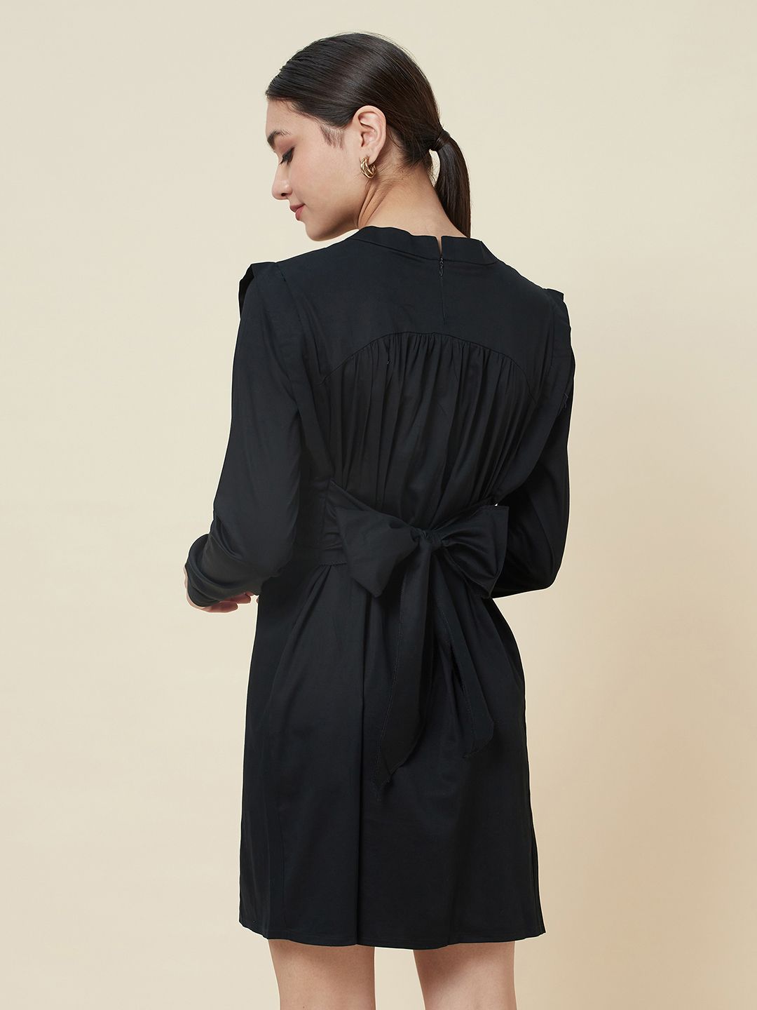 Black high neck dress with side smocking and a belt to cinch the waist